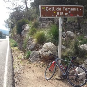 Road bike leaning against the Coll de Femenia 515 m sign beside the road