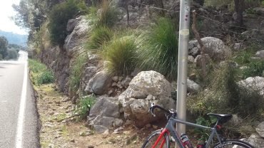 Road bike leaning against the Coll de Femenia 515 m sign beside the road