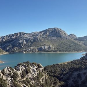 Turquoise mountain reservoir surrounded by limestone peaks and Mediterranean scrub in the Serra de Tramuntana