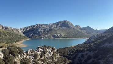 Turquoise mountain reservoir surrounded by limestone peaks and Mediterranean scrub in the Serra de Tramuntana